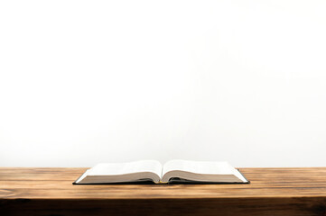 Open Bible book on a wooden table.
