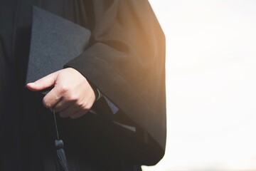 Close up graduate. man holding a hat.