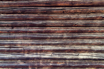 Background of a textured old wall made of brown wooden beams.