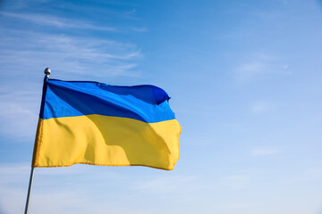 National flag of Ukraine against blue sky. Space for text