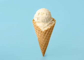 Delicious ice cream in waffle cone on light blue background