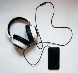 Smartphone and headphones on white background