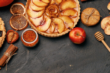 Tart pie and red apple on black table