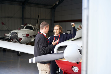 Female flight instructor teaching her student how to do the maintenance of the plane. © CarlosBarquero