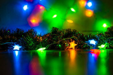 Toy balls on the Christmas tree and cones with multi-colored garlands close-up.