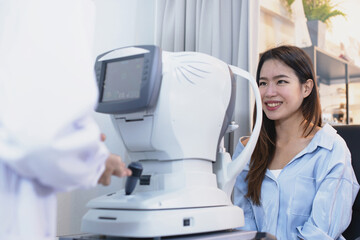 Asian woman looking optometrist , optical phoropter nearby, diagnostic ophthalmology equipment, selective focus