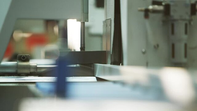 Buzzsaw cutting metal profile automatically in big warehouse/workshop 4k PRORES Footage