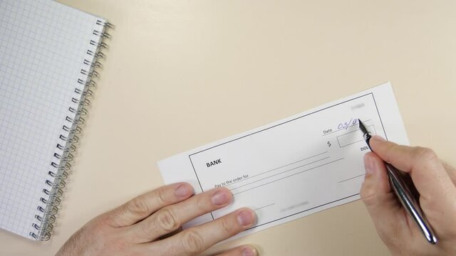 Business man writes a bank check.