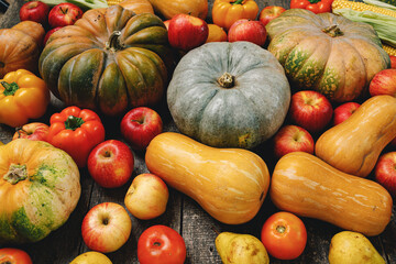 Pumpkins and red apples on wooden background