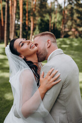 Portrait of the bride and groom. Walk the newlyweds in the open air. Beautiful summer photo session.
