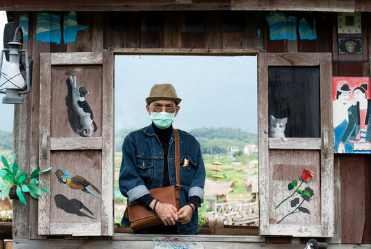 Tourists in medical mask wearing jacket jean in wooden window and natural background. Medical mask protection against pollution, flu and coronavirus. Travel, Health care to be safe concept.