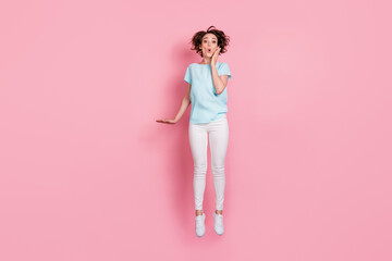 Fototapeta na wymiar Full length photo of shocked surprised woman wear casual outfit jumping hand arm cheek isolated pink color background