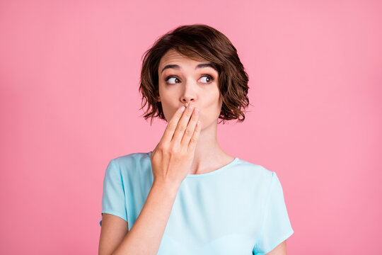 Photo of cute cunning woman wear casual blue t-shirt arm cover mouth look empty space isolated pink color background