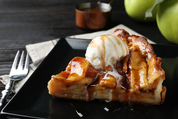 Slice of traditional apple pie with ice cream served on table, closeup