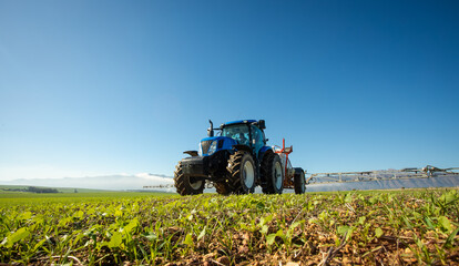 Wide angle image of a crop spray machine spraying chemicals on wheat crop on a farm in south africa - obrazy, fototapety, plakaty