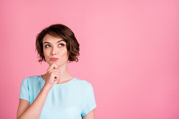 Photo of dreamy sweet woman wear casual blue t-shirt look empty space arm chin isolated pink color background