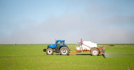 Wide angle image of a crop spray machine spraying chemicals on wheat crop on a farm in south africa