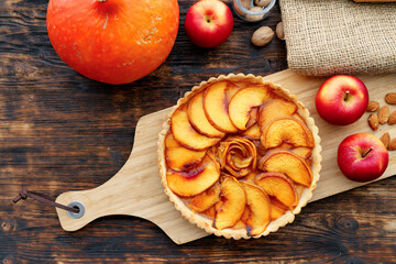 Apple tart pie and red apples on wooden table