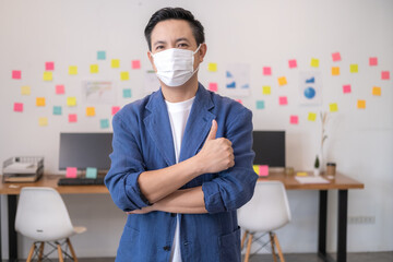 Asian workers in offices wear face masks to prevent the spread of COVID-19. Working in the new normal era and Social distance.