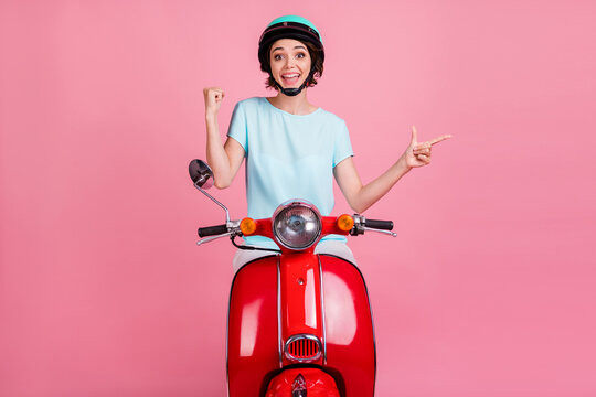 Photo Of Positive Cute Young Lady Ride Red Moped Show Which Side To Go Wear Blue Outfit Slam Isolated On Pastel Pink Background