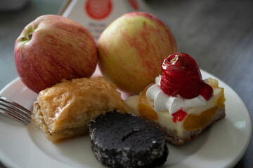 Baklava, cake and apples are on a plate