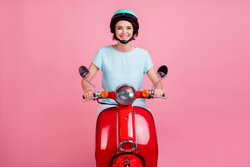 Photo of positive pretty girl ride moped enjoy road wear blue t-shirt slam isolated on pastel pink...