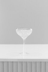 Cocktail glass wineglass with silver golden border on a bar counter on a white grey background