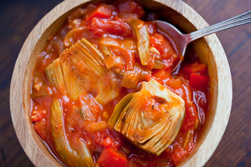 Provensal artichoke ragout in wooden bowl