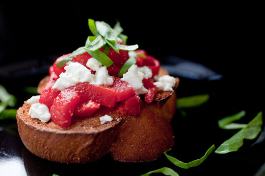 Close up of bruschetta with roasted peppers and goat cheese