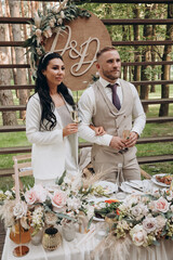 The bride and groom at the wedding table are receiving congratulations. European wedding.