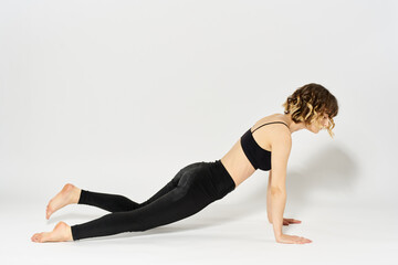 Fototapeta na wymiar Sportive woman will do the exercise lying on the floor Gymnastics fitness in a bright room