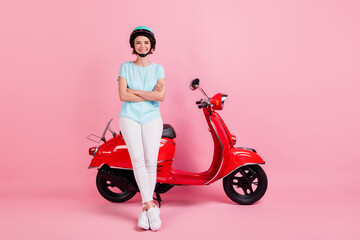 Fototapeta na wymiar Photo of positive cute young lady stand moped crossed arms wear white trousers footwear blue slam t-shirt isolated on pink background