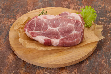 Raw pork steak over wooden board