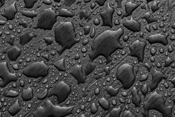 Abstract pattern of water drops after rain on a painted wooden surface. Top view, close-up on dark...