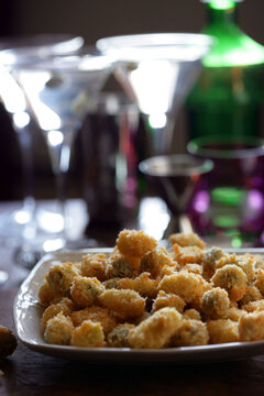 Close up of deep fried garlic cloves and green olives