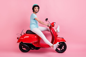 Fototapeta na wymiar Profile photo of impressed funny young women ride moped legs up wear white trousers sneakers blue slam t-shirt isolated on pink background