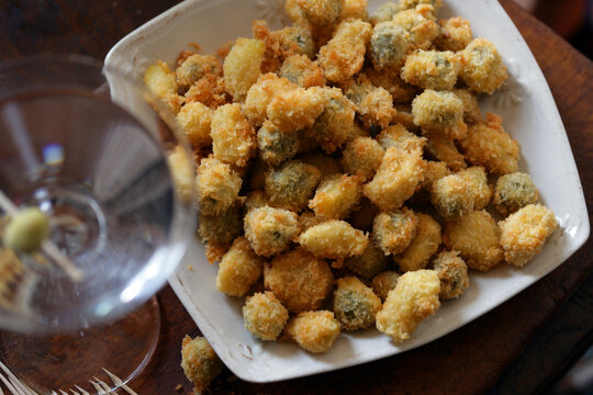 Close up of deep fried garlic cloves and green olives
