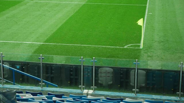 A yellow corner flag waving in the wind on a football or soccer field. View from the stadium tribune. High quality 4k footage