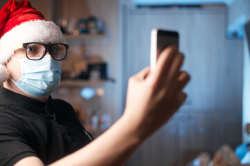 Fototapeta na wymiar Christmas concept, caucasian man wearing medical mask and santa hat