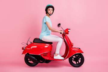 Fototapeta na wymiar Profile photo of excited young women motorcyclist ride moped wear white trousers shoes blue t-shirt isolated on pink background