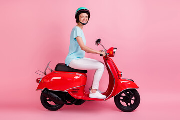 Fototapeta na wymiar Profile photo of positive cheerful women motorcyclist ride moped wear white pants blue t-shirt isolated on pink background