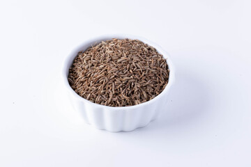 Cumin in a white ceramic cup on a white background