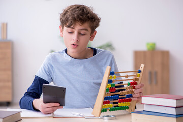 Schoolboy with abacus studying math at home