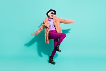 Photo of cheerful sweet senior lady wear retro jacket headwear eyeglasses dancing isolated teal color background
