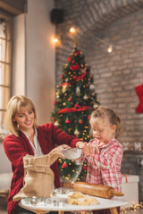 Mother and daughter kneading dough for gingerbread Christmas cookies