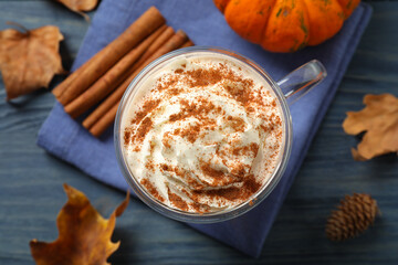 Delicious pumpkin latte on blue wooden table, top view