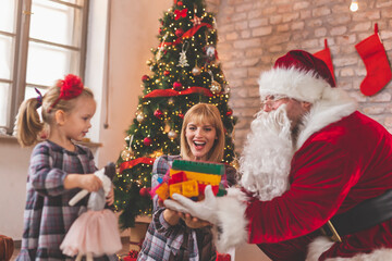 Fototapeta na wymiar Santa giving Christmas presents to little girl