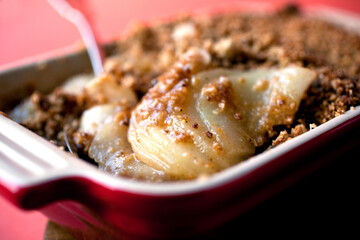 Close up of baked pear with ginger crumble dessert