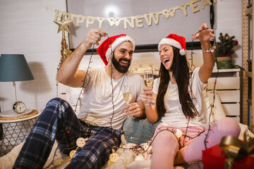 Fototapeta premium Merry Christmas and Happy New Year! Attractive young couple is celebrating holiday at home together.