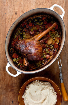 Close up of braised leg of lamb with olives and celery root puree